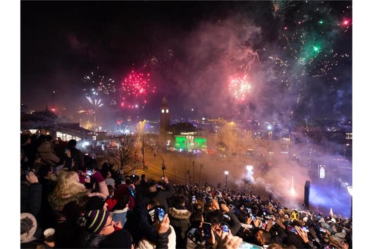 Hunderte Schaulustige beobachten das Feuerwerk an den Hamburger Landungsbrücken. Foto: Jonas Walzberg/dpa