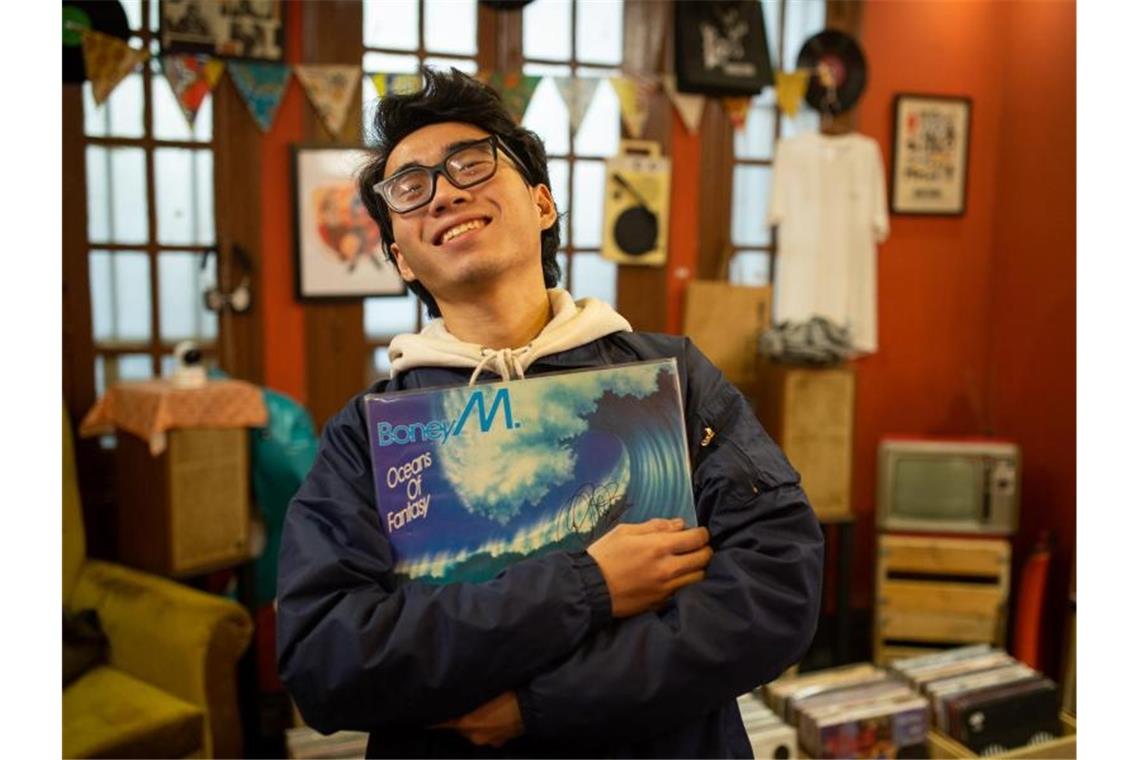 Hung, Mitarbeiter des LP Club, hält die Schallplatte „Oceans of Fantasy“ von Boney M. Wenn in Vietnam geheiratet wird, darf Boney M so gut wie nie fehlen. Foto: Chris Humphrey/dpa