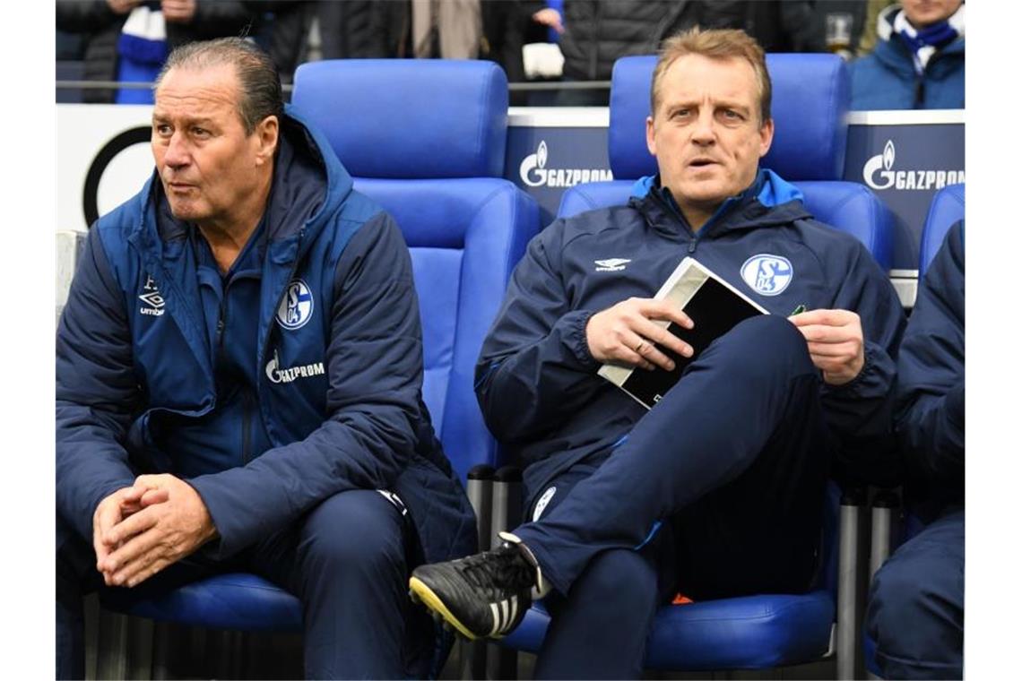 Huub Stevens (l) und Mike Büskens von Schalke sitzen auf ihren Plätzen. Foto: Ina Fassbender/dpa/Archiv