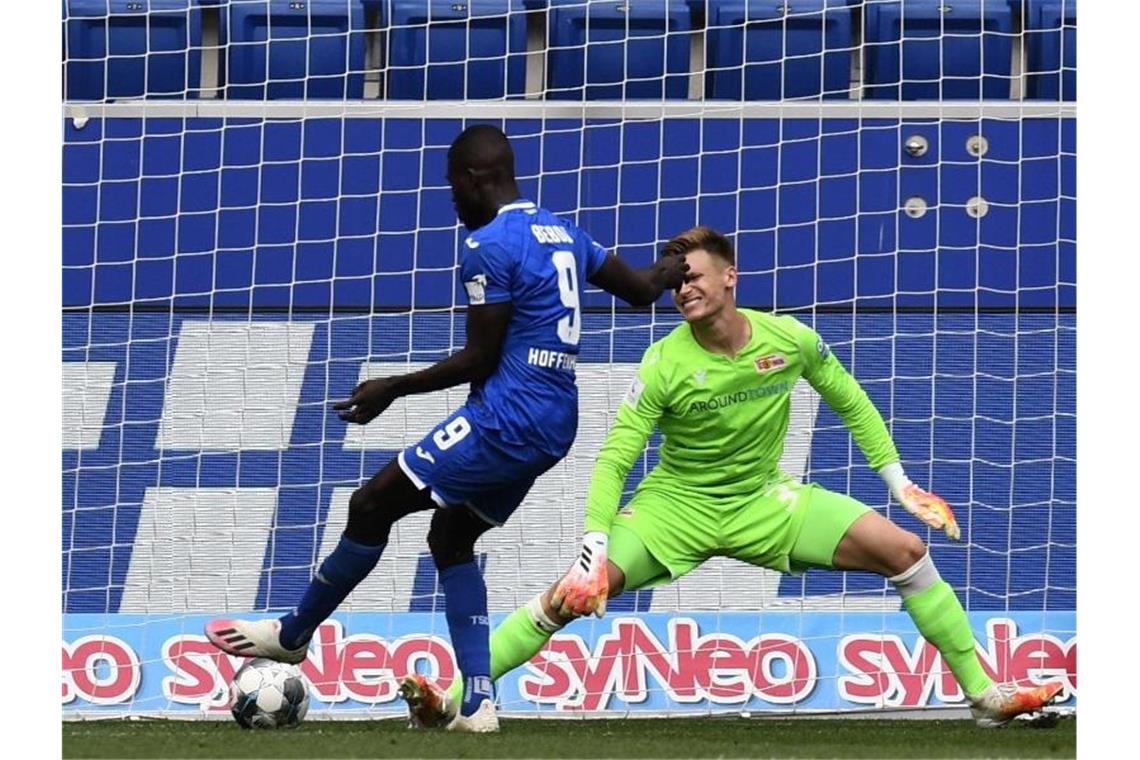 Ihlas Bebou (l) von 1899 Hoffenheim erzielt das Tor zum 1:0 gegen Unions Torwart Moritz Nicolas. Foto: Thomas Kienzle/AFP Pool/dpa