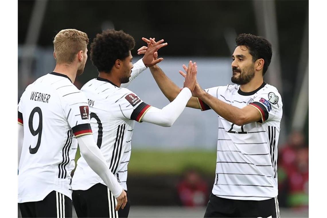 Flick erfüllt Neun-Punkte-Plan: DFB-Elf siegt auf Island Ilkay Gündogan (r) gratuliert Torschütze Serge Gnabry (M). Foto: Christian Charisius/dpa