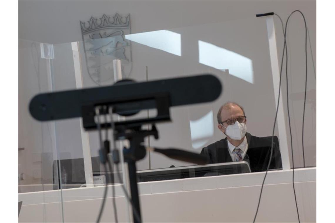 Im Arbeitsgericht sitzt Richter Nikolaus Zimmermann vor einer Webcam hinter einer Plexiglasscheibe. Foto: Stefan Puchner/dpa