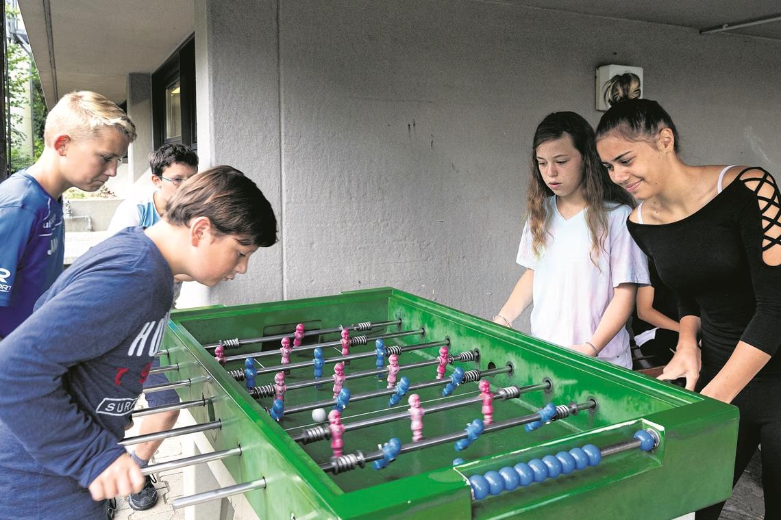 Im Atrium des Mönchhof-Geländes stehen neben Tischtennisplatten auch zwei Tischkicker. Jannick, Jan, Salome und Hanna (von links) sind dort gerne. Später geht es in die Hobbygruppen. Foto: J. Fiedler