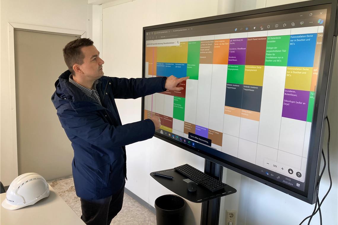 Wie aus dem Rohbau eine Sporthalle wird Im Büro der Bauleitung kann Projektleiter Hasan Garic den Zeitplan überblicken. Die unterschiedlichen Gewerke sind dabei durch verschiedene Farben dargestellt.