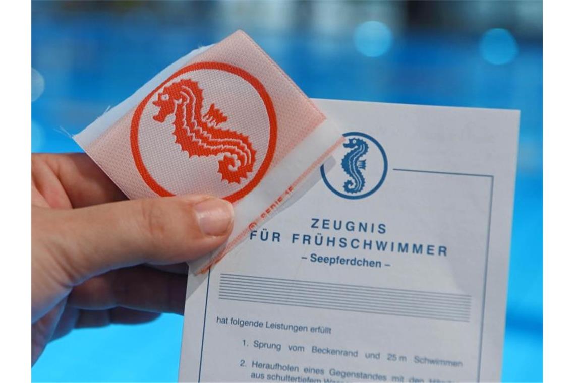 Im Fächerbad wird vor dem Schwimmbecken ein Seepferdchen Schwimmabzeichen gezeigt. Foto: Uli Deck/dpa/Symbolbild