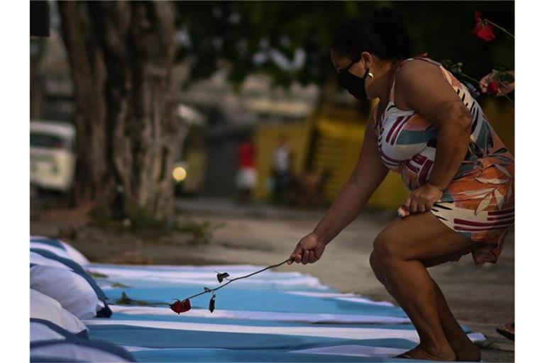 Im Gedenken an die rund 300.000 Corona-Toten in Brasilien legt eine Frau eine Rose ab. Foto: Andre Borges/dpa