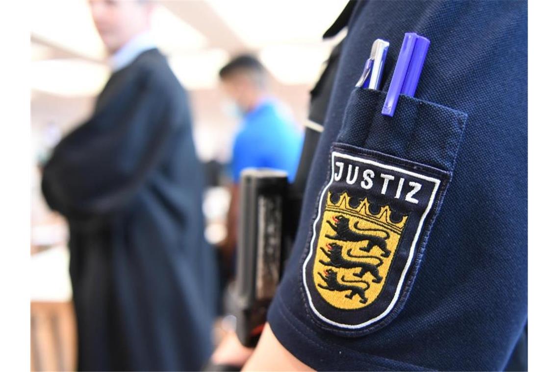 Im Hintergrund steht ein Angeklagter im Prozess vor dem Landgericht Ulm um die Vergewaltigung einer 14-Jährigen. Foto: Felix Kästle/dpa
