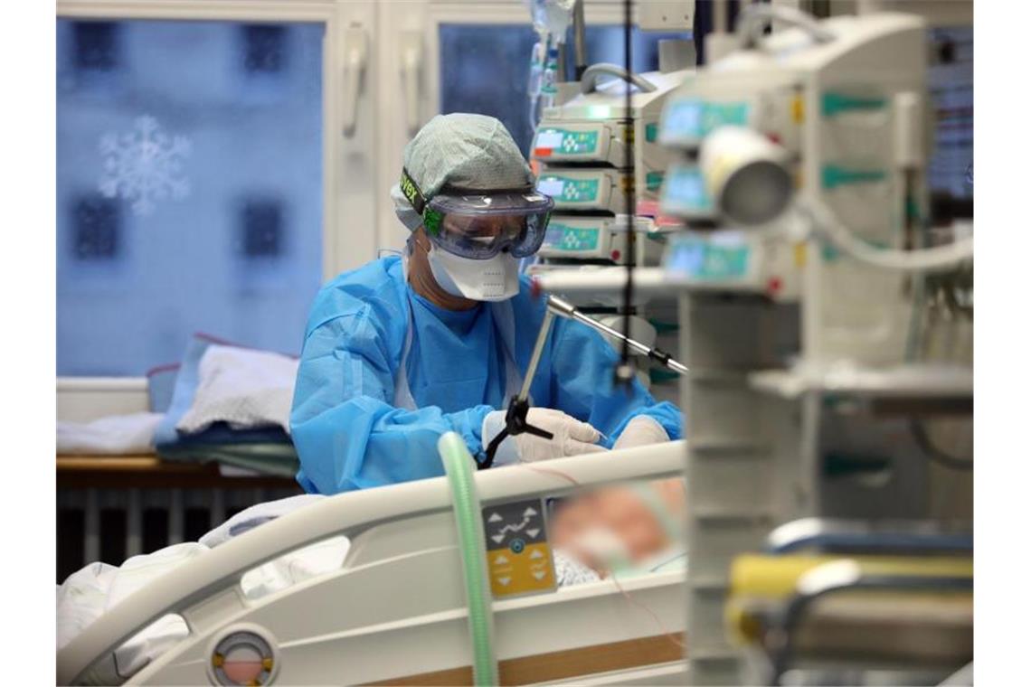 Corona-Inzidenz steigt zum fünften Mal in Folge deutlich Im Infektionszimmer für Covid-19-Patienten auf der Intensivtherapiestation der Universitätsmedizin Rostock wird ein Patienten im künstlichen Koma gepflegt. Foto: Bernd Wüstneck/dpa-Zentralbild/dpa