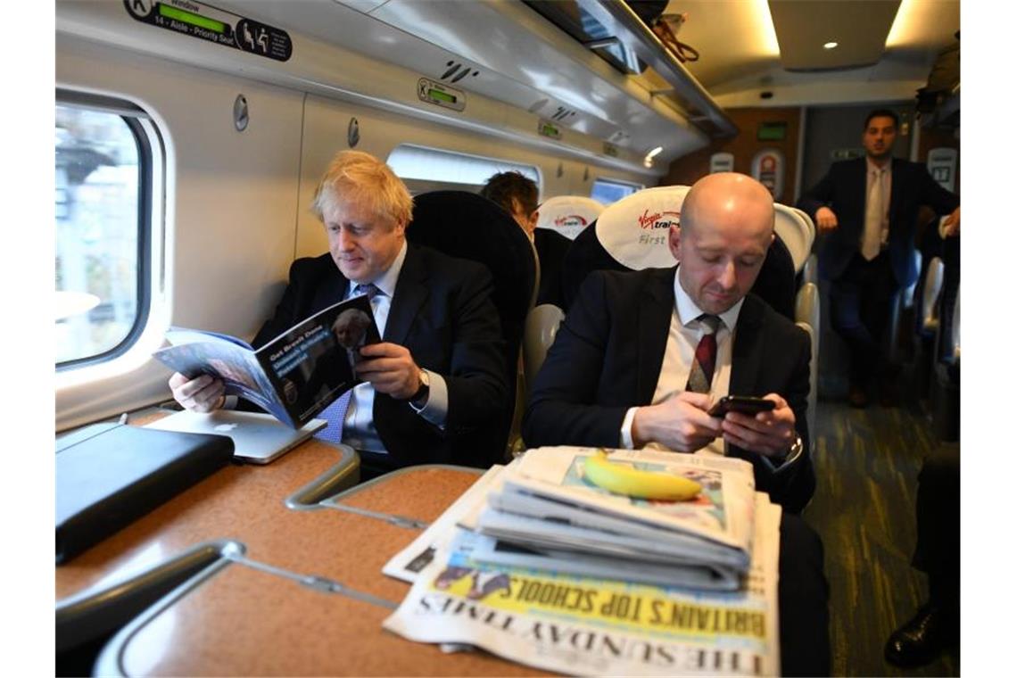 Im November 2019 sind Lee Cain (r) und Boris Johnson noch gemeinsam auf Reise. Foto: Stefan Rousseau/PA Wire/dpa