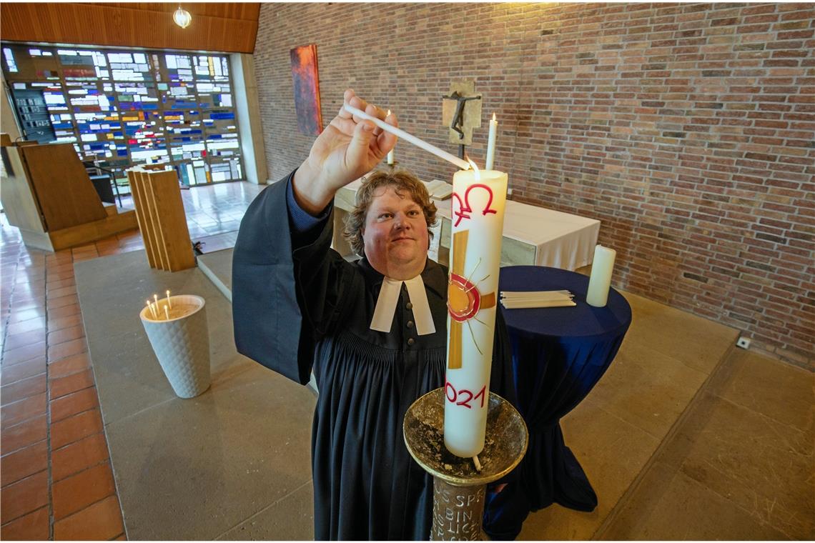 Im Rahmen des Zoom-Gottesdiensts der Backnanger Matthäusgemeinde entzündete gestern auch Pfarrer Tobias Weimer zum Gedenken an die Opfer der Pandemie Kerzen an der Osterkerze. Foto: A. Becher