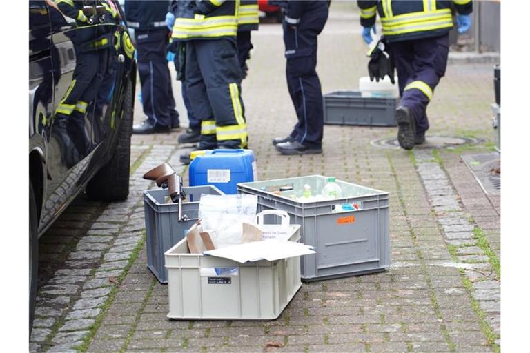 Im Rahmen einer Wohnungsdurchsuchung in Lahr stehen Kisten auf einem Gehweg. Foto: Benedikt Spether/dpa
