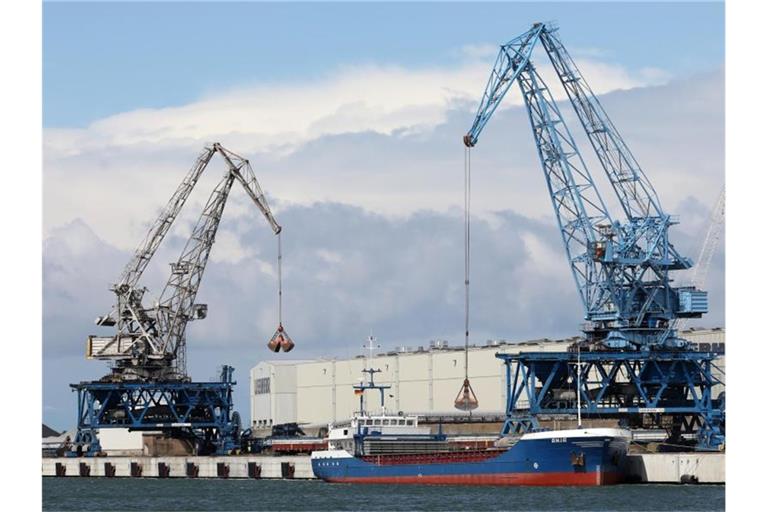 Im Seehafen an der Ostsee wird ein Schiff mit Kränen abgefertigt. Foto: Bernd Wüstneck/dpa-Zentralbild/dpa