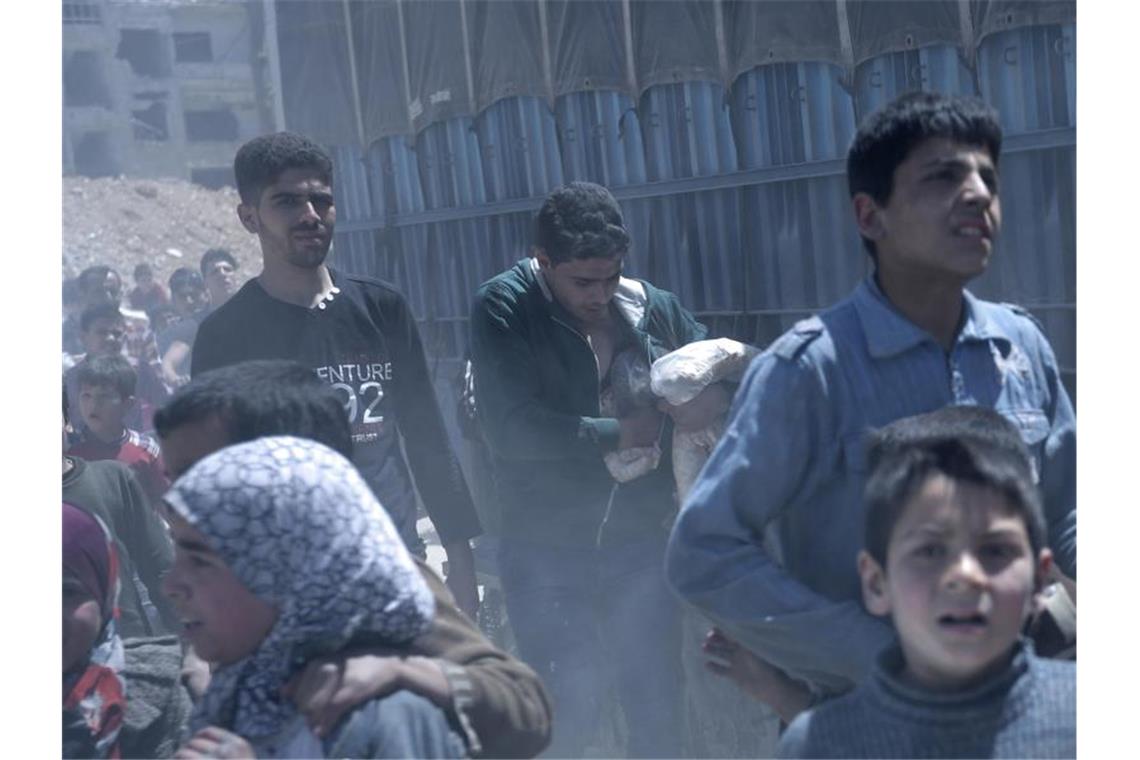 Syrien-Konflikt: Deutschland sagt für Opfer Milliarden zu Im syrischen Duma werden - hier im Jahr 2018 im Auftrag der Regierung - Lebensmittel ausgeteilt. Foto: Hassan Ammar/AP/dpa