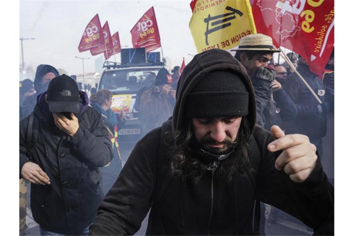 Im Tränengasnebel: Demonstranten während eines Protestes gegen die geplanten Rentenreformen in Frankreich. Foto: Laurent Cipriani/AP/dpa