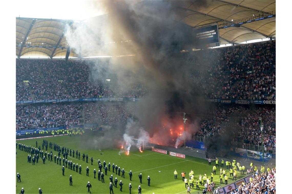 Im Volksparkstadion in Hamburg explodireen Feuerwerkskörper vor dem Abpfiff. Foto: Axel Heimken/dpa