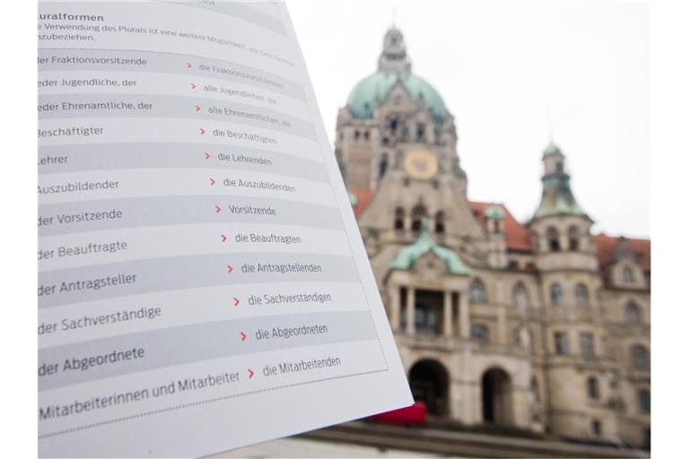 Im Vordergrund ein Ausschnitt aus „Empfehlungen für eine geschlechtergerechte Verwaltungssprache“, im Hintergrund das Rathaus von Hannover. Foto: Julian Stratenschulte