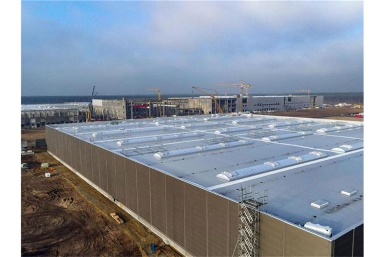 Im Vordergrund ist das Gebäude der Lackiererei auf der Baustelle der Tesla Gigafactory in der Nähe von Berlin zu sehen. Foto: Patrick Pleul/dpa-Zentralbild/dpa