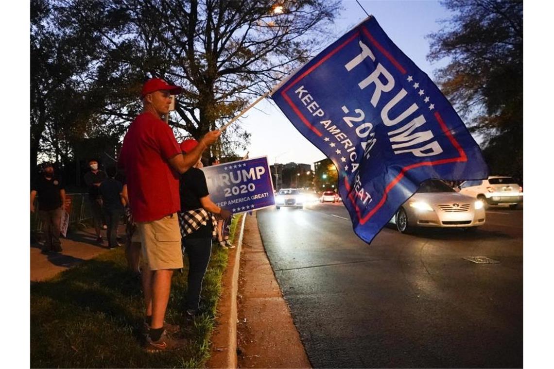 Im Vorfeld der TV-Debatte wartet ein Trump-Unterstützer mit einer Fahne auf sein Idol. Foto: Mark Humphrey/AP/dpa