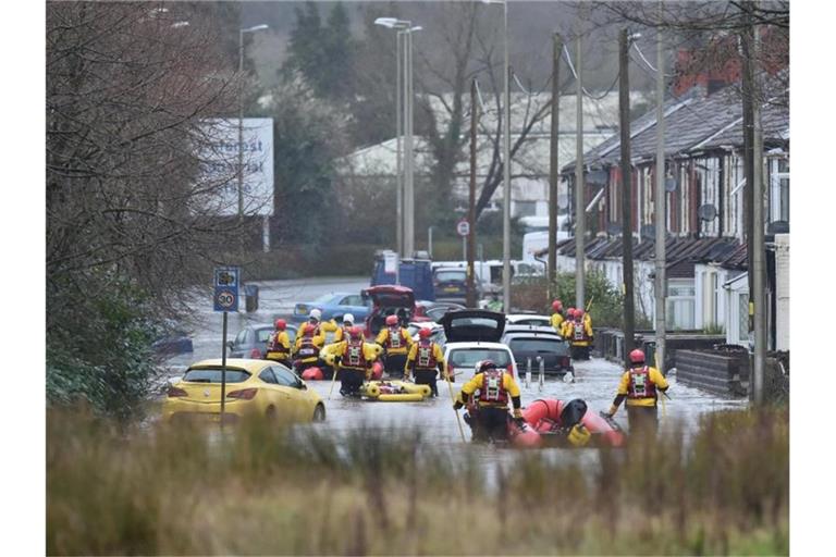 Im walisischen Nantgarw sind Rettungskräfte auf einer überschwemmten Straße im Einsatz. Foto: Ben Birchall/PA Wire/dpa