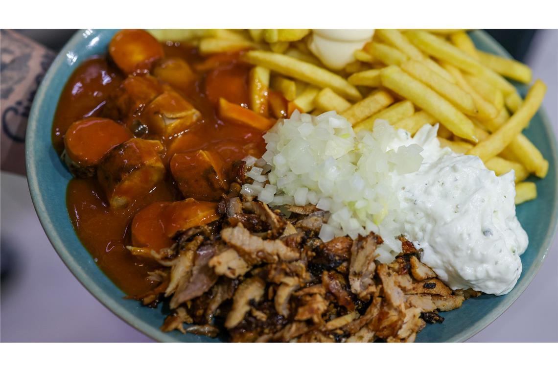 Imbiss mit Gehalt: Currywurst (links), Pommes frites mit Mayonnaise (oben) und Gyrosfleisch mit Zwiebeln und Tzatziki.