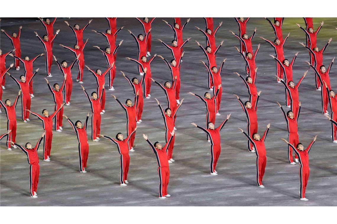 Bilder des Tages Immer schön gleichförmig: Teilnehmer bei den Feierlichkeiten zum 80. Jahrestag der Gründung der regierenden Arbeiterpartei zeigen eine Choreographie im nordkoreanischen Pjöngjang.