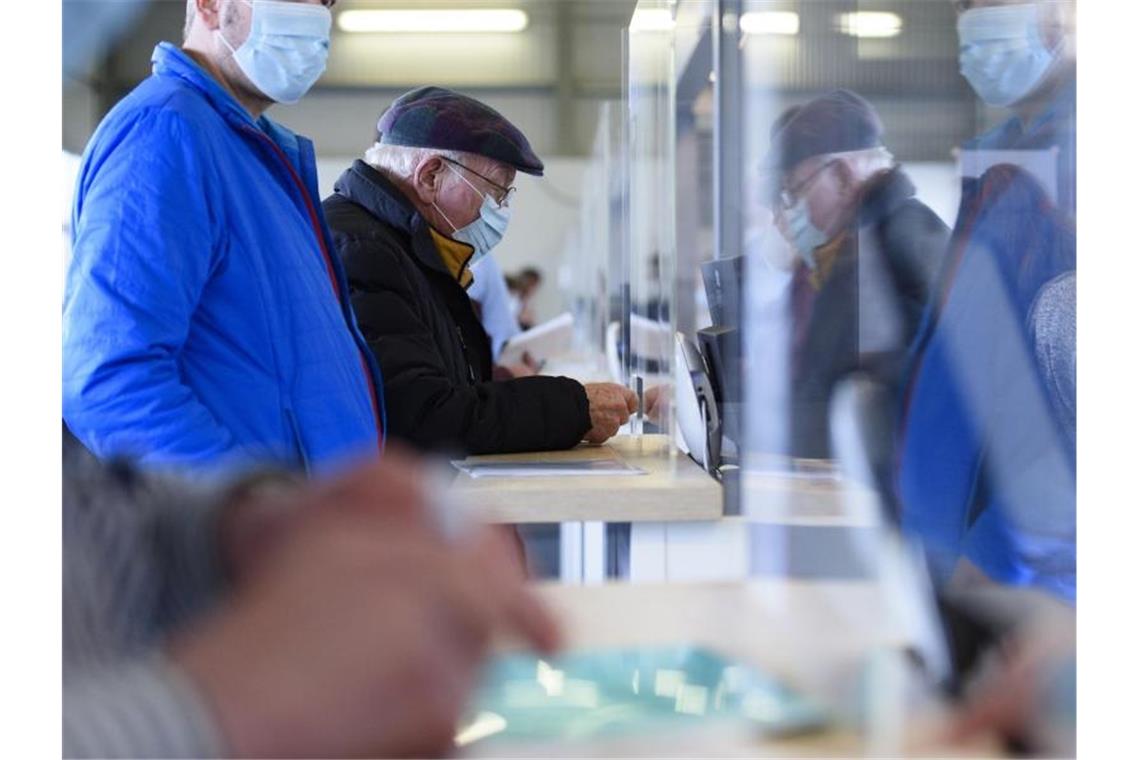 Bekommen Geimpfte früher ihre Freiheitsrechte zurück? Impfberechtigte im Eingangsbereich eines Impfzentrums. Foto: Christopher Neundorf/dpa