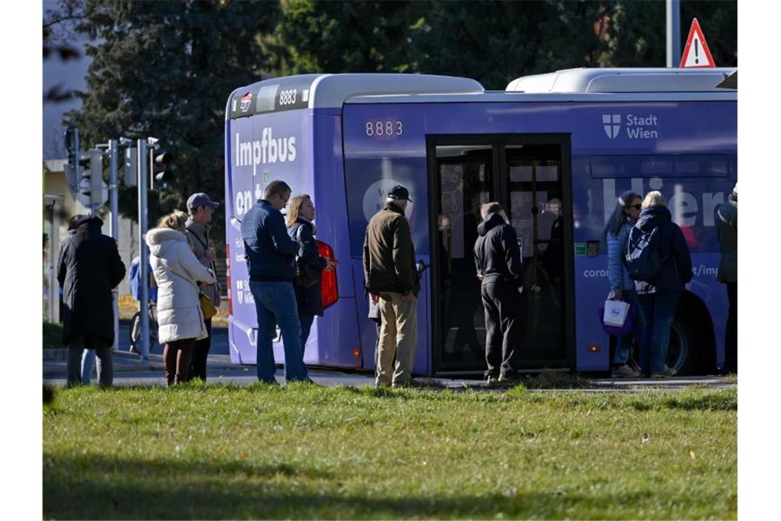 Impfwillige stehen vor einem Impfbus in Wien. Ab heute gilt die 2G-Regel für den gesamten Freizeitbereich. Foto: Herbert Neubauer/APA/dpa