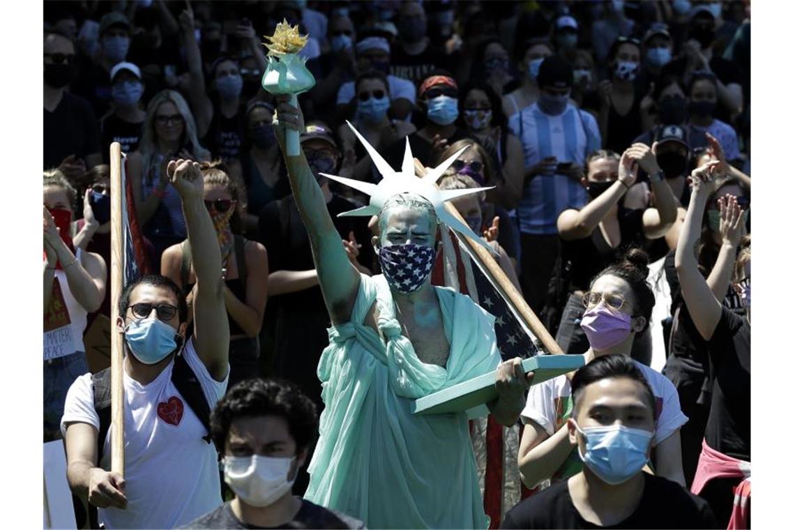 In Chicago hat sich eine Demonstrant als Freiheitsstatue verkleidet. Foto: Nam Y. Huh/AP/dpa