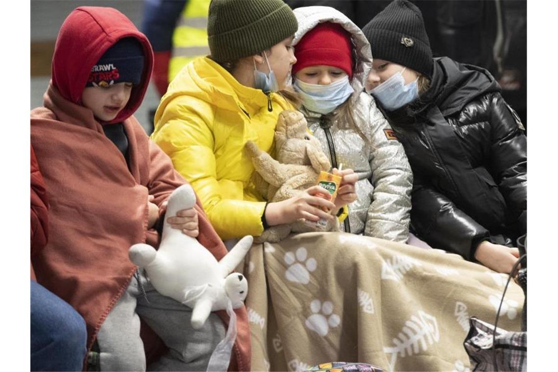 Rund 37.800 ukrainische Flüchtlinge in Deutschland In Decken gehüllt sitzen diese Kinder aus dem ukrainischen Kriegsgebiet auf einer Bank im Berliner Hauptbahnhof. Foto: Paul Zinken/dpa