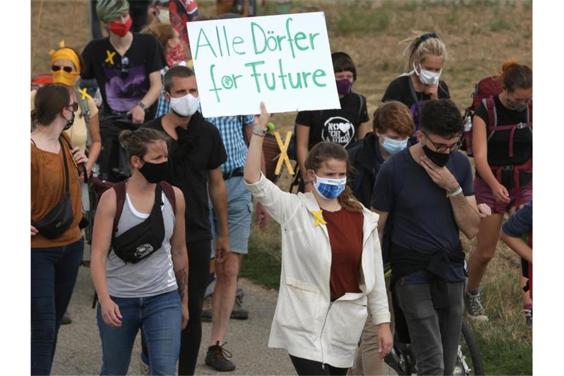 Demo und Besetzung in Garzweiler In dem Demonstrationszug aus Keyenberg zeigt Luisa Neubauer (M) ein Plakat mit der Aufschrift „Alle Dörfer for Future“. Foto: David Young/dpa