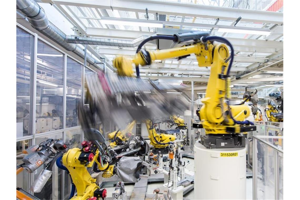 In der deutschen Industrie scheint es wieder aufwärts zu gehen: Industrieroboter schweißen in einer Volkswagen Autofabrik Teile an. Foto: picture alliance / Silas Stein/dpa