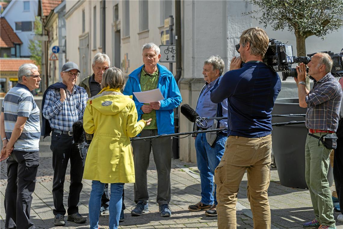 In der Fußgängerzone darf eine Herrentruppe gemeinsam über die fehlenden Wörter in einem Liedtext knobeln.