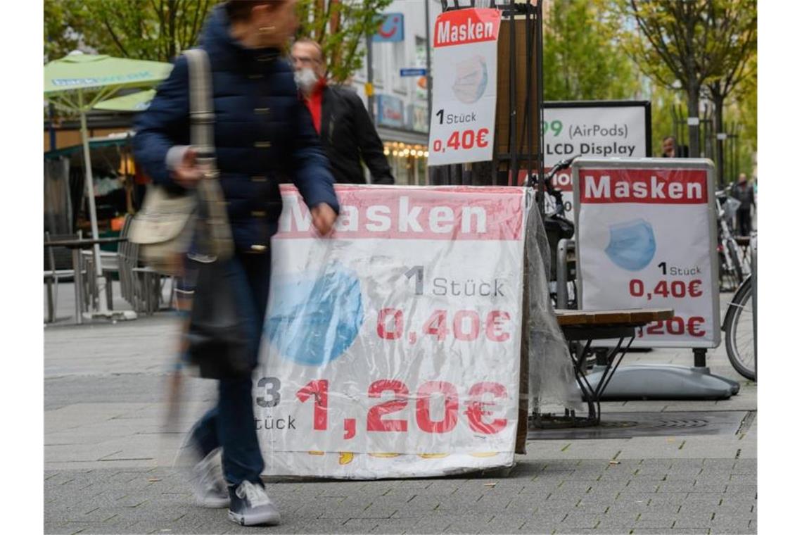 In der Fußgängerzone von Offenbach werben mehrere Plakate für Masken. Foto: Andreas Arnold/dpa
