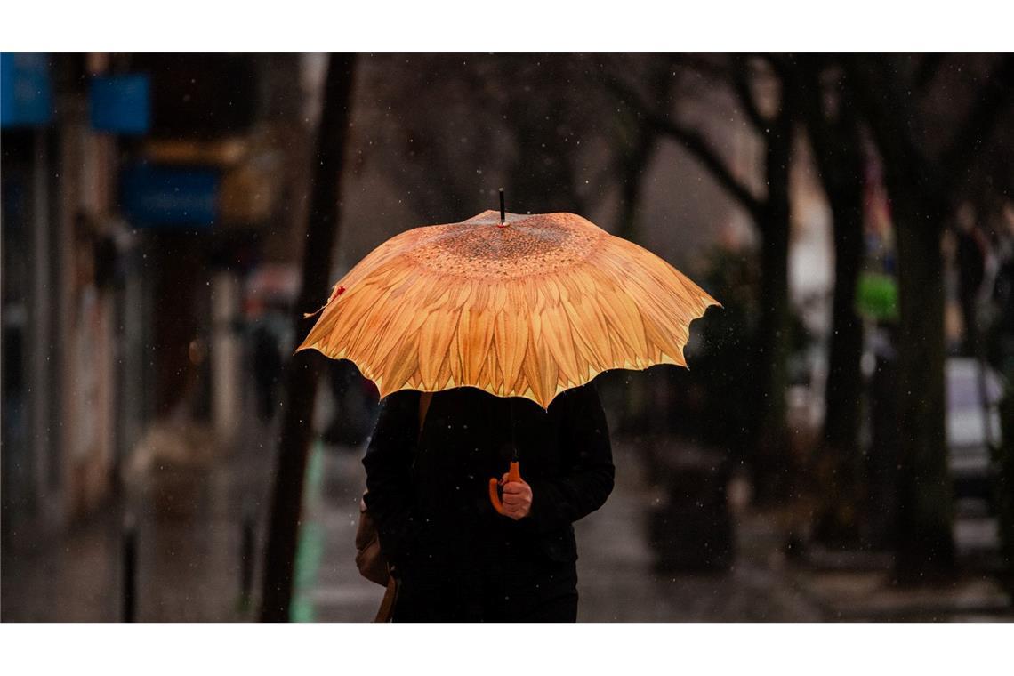 In der gesamten Region Madrid wurde eine Warnung für Regen und Schnee herausgegeben. Diese Person schützt sich mit einem Schirm.