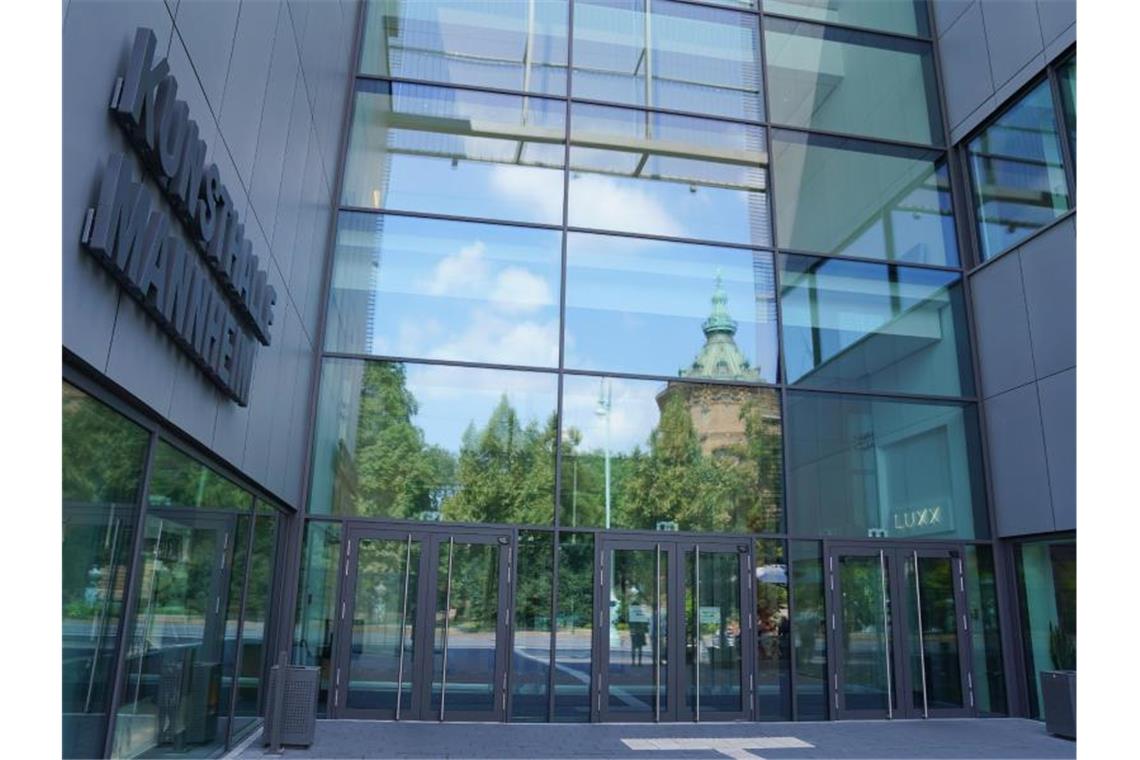 In der Glasfassade am Haupteingang der Kunsthalle spiegelt sich der Mannheimer Wasserturm. Foto: Uwe Anspach/dpa/Archivbild