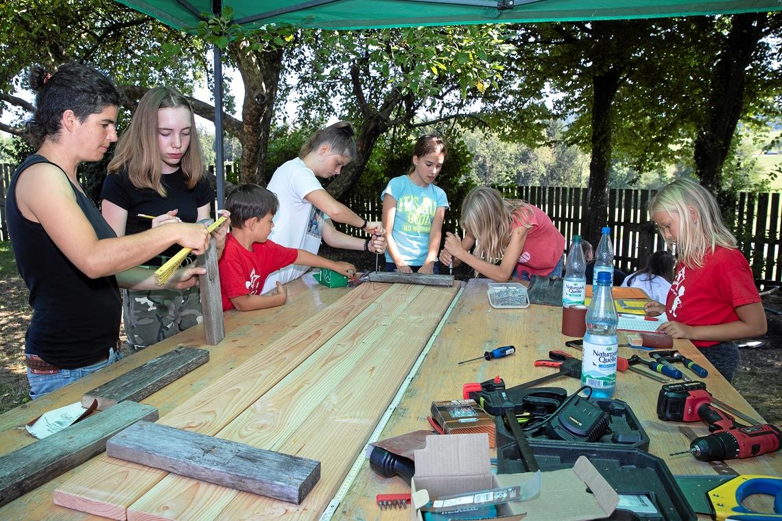 Ferien mit Buddelglück und Apfelbaum In der Holzwerkstatt wird schwer getüftelt. Das Projekt: Gemeinsam einen Sandkasten fürs Freizeitheim bauen und installieren. Veronika Ziegler (links) leitet die Kleingruppe an. Sie unterstützt die Freizeit außer der Reihe als Schreinerin. Foto: J. Fiedler