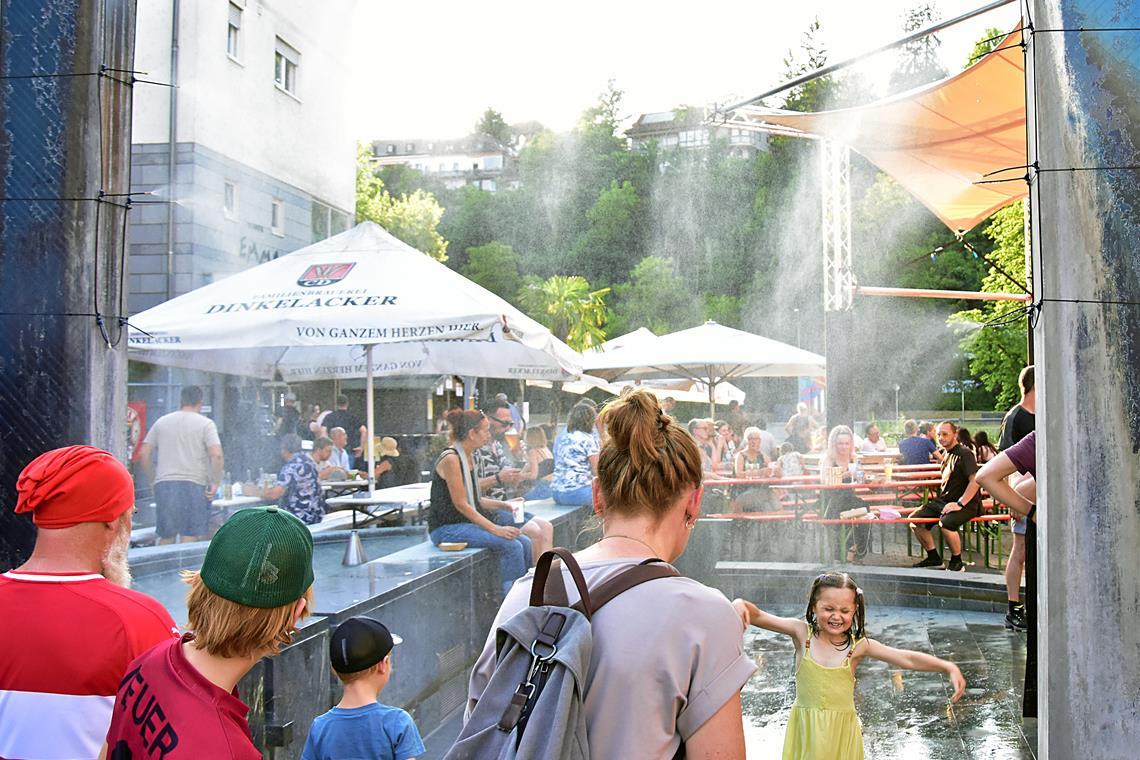 In der Mittagssonne beginnt ein Mädchen am Sonntag, unter dem künstlichen Regen zu tanzen. Fotos: Tobias Sellmaier