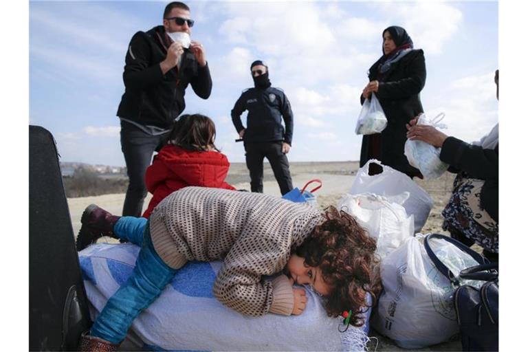 In der Nähe des Grenzübergangs Pazarakule ruht such ein Kind auf einem Sack mit Habseligkeiten aus. Foto: Darko Bandic/AP/dpa
