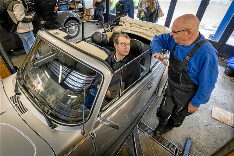 In der Werkstatt von Thomas Canz (rechts) und Thomas Erk dreht sich alles um alte VW Käfer. In einem Cabrio nimmt Maximilian Friedrich spontan selbst Platz. Foto: Alexander Becher