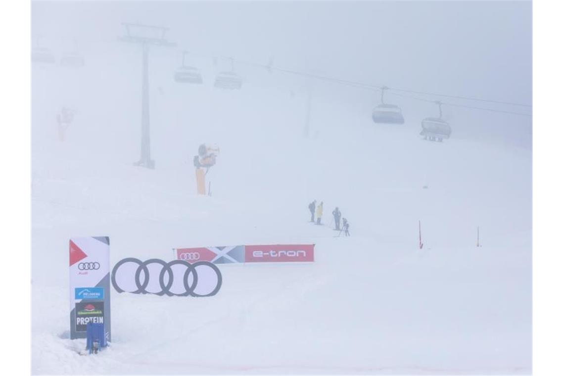 In dichtem Nebel stehen Menschen an der Strecke des Skicross-Weltcups auf dem Feldberg. Foto: Philipp von Ditfurth/dpa