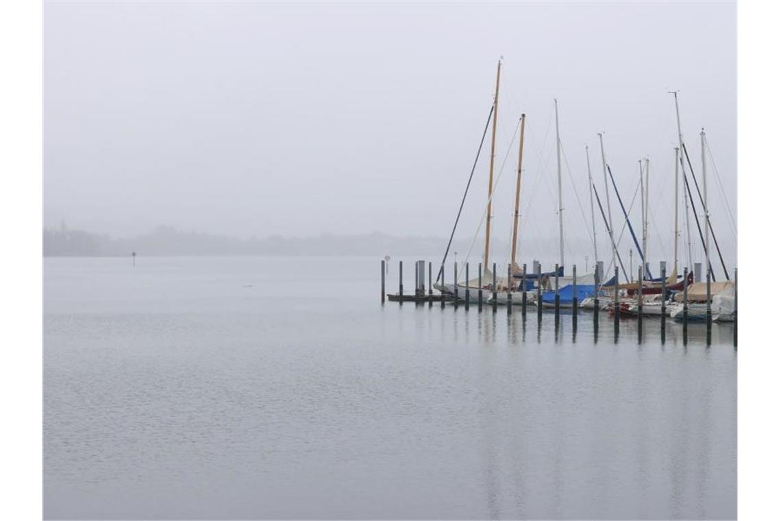 In Dunst und Regen liegen die Segelboote des Yachthafens am Bodensee. Foto: Karl-Josef Hildenbrand/dpa