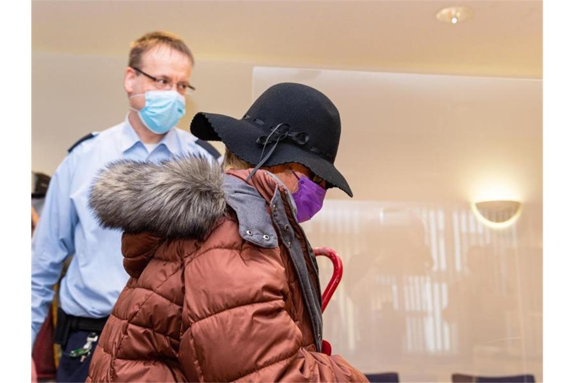 Schuldunfähig durch Liebeswahn: Freispruch für Stalkerin In einem Berufungsprozess wird die heute 79-Jährige Angeklagte im Landgericht Arnsberg durch einen Justizvollzugsbeamten an ihren Platz begleitet. Foto: Guido Kirchner/dpa