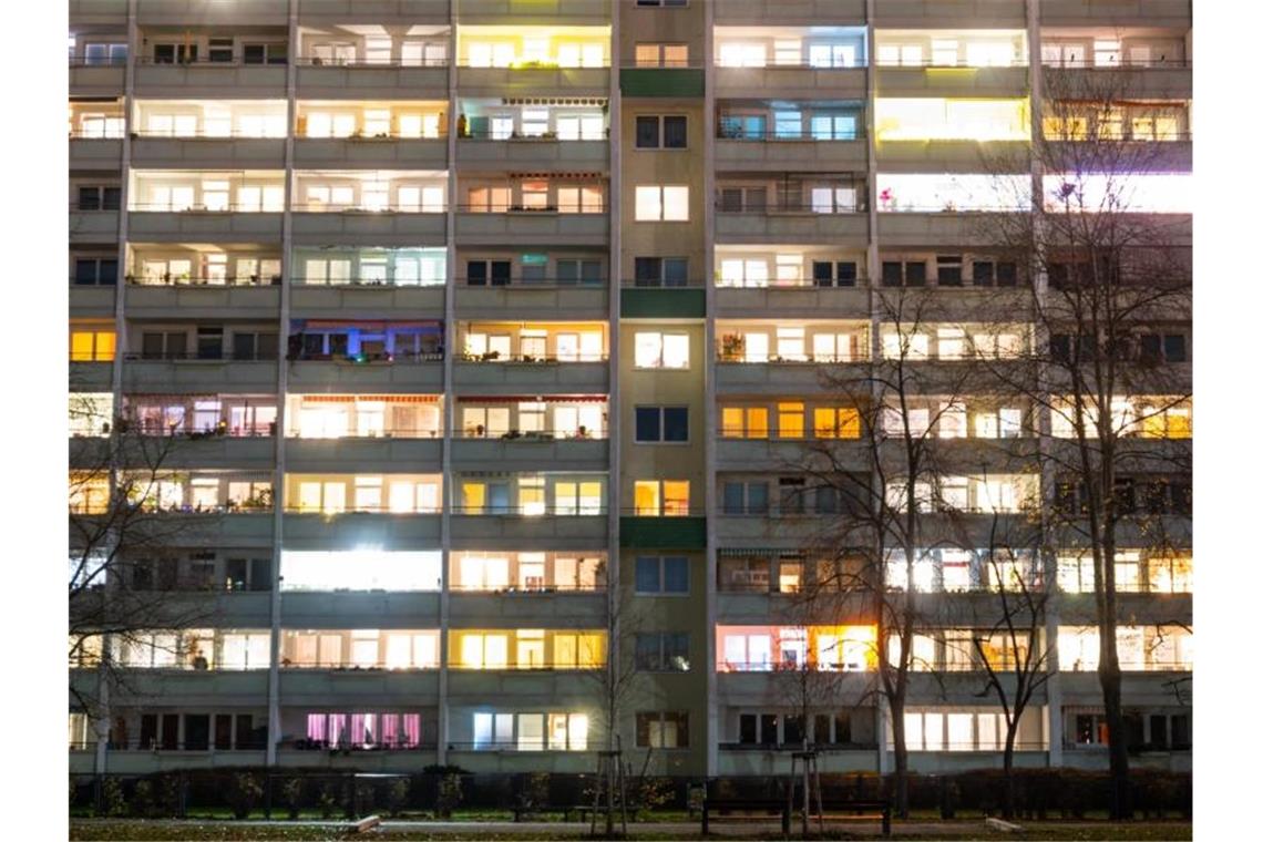 Klimaschutz auf Mieterkosten? Soziale Vermieter besorgt In einem Hochhaus sind einige Fenster beleuchtet. Foto: Christophe Gateau/dpa