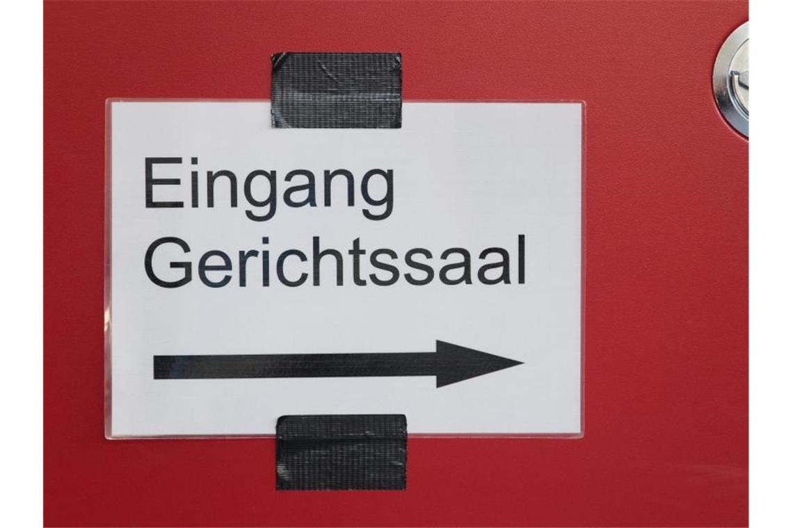 In einem Justizgebäude weist ein Schild den Weg zum Gerichtssaal. Foto: Friso Gentsch/dpa