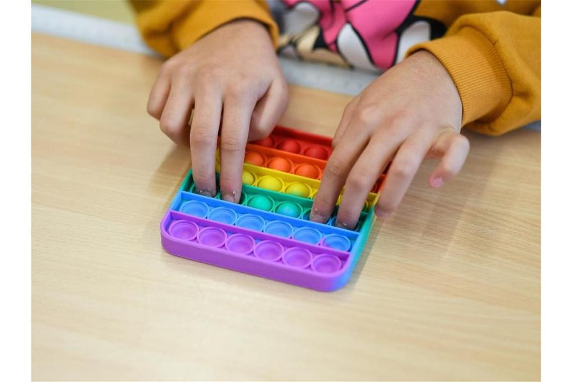 Hype um Trendspielzeug Pop-Its - auch an Schulen ein Thema In einem Klassenzimmer einer Bielefelder Grundschule spielt ein Kind mit Pop-Its. Foto: Guido Kirchner/dpa