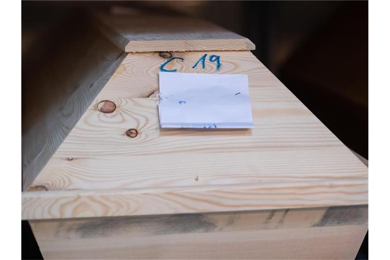 In einem Krematorium ist ein Sarg mit „C19“ (für Covid-19) markiert. Foto: Julian Stratenschulte/dpa
