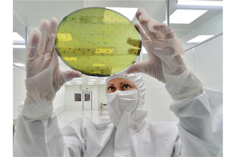 In einem Reinraum wird ein Siliziumwafer für die Halbleiterherstellung geprüft. Foto: Martin Schutt/dpa-Zentralbild/dpa