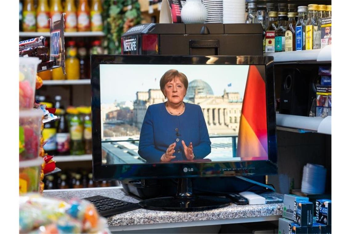 Kanzlerin appelliert in Coronakrise an Disziplin der Bürger In einem Spätkauf läuft die TV-Ansprache von Bundeskanzlerin Merkel auf einem kleinen Fernseher. Foto: Christophe Gateau/dpa