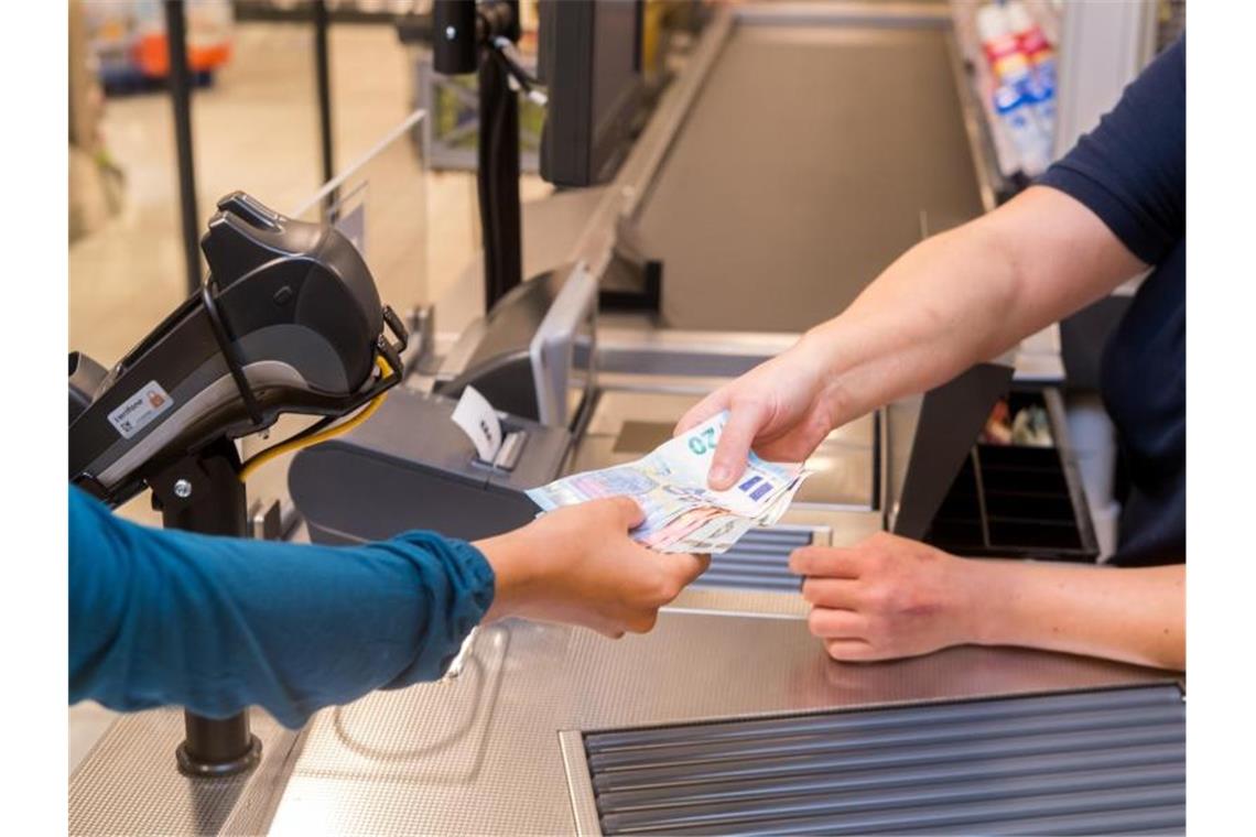 In einem Supermarkt hebt eine Kundin beim Bezahlen auch gleich Bargeld ab. Foto: Benjamin Nolte/dpa-tmn/dpa