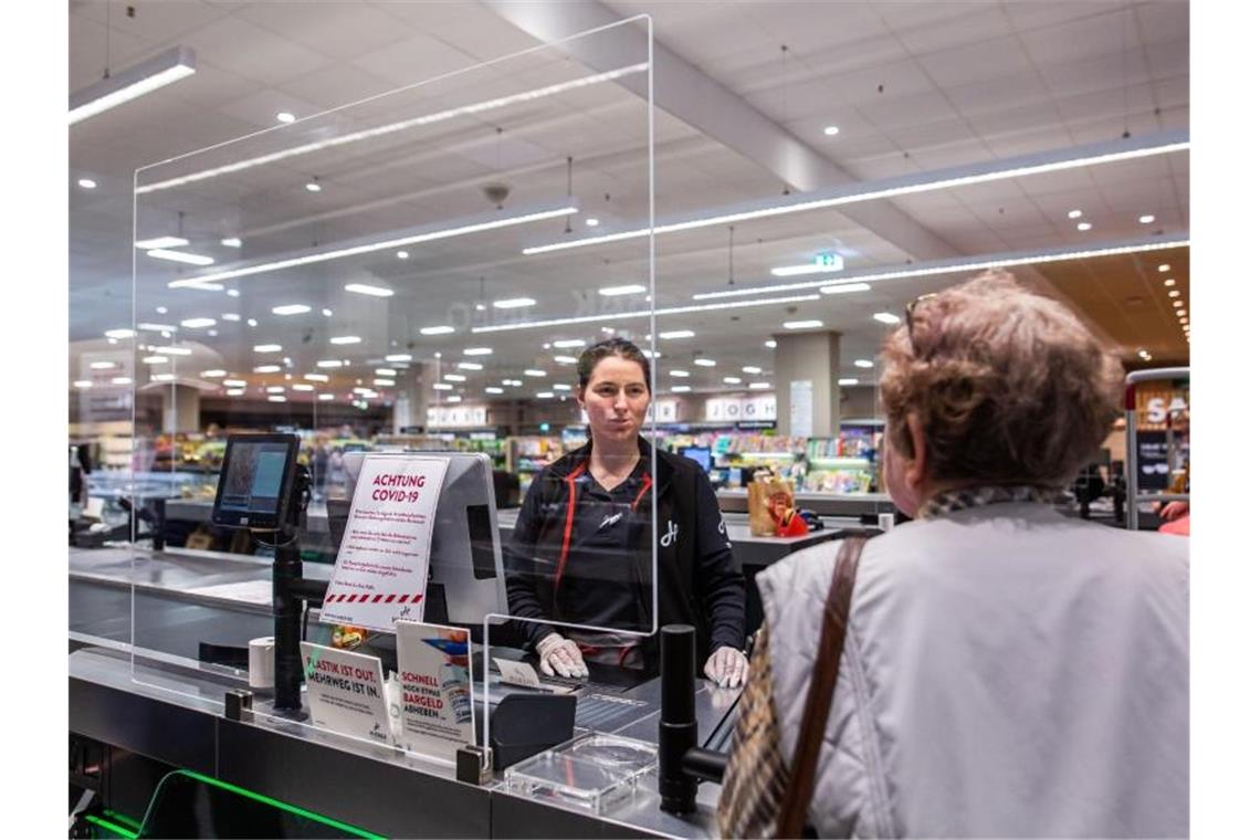 In einem Supermarkt in Rheinfelden in Baden-Württemberg wird die Kassiererin von einer Plexiglasscheibe geschützt. Foto: Philipp von Ditfurth/dpa